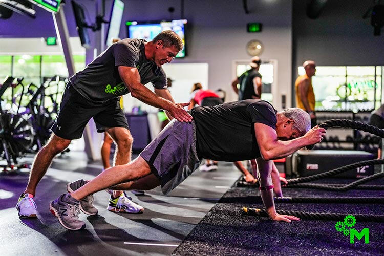 Method Training coach assisting a woman wit an exercise
